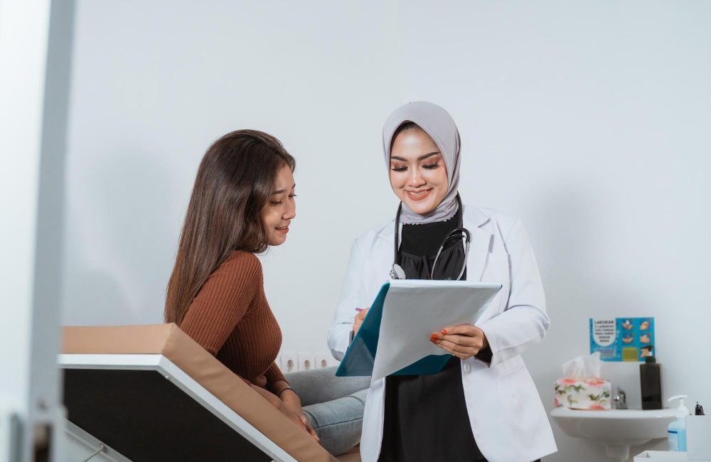 An obstetrician and gynaecologist is checking a woman.