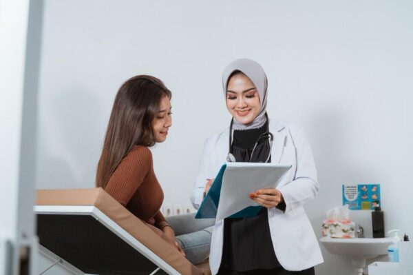 An obstetrician and gynaecologist is checking a woman.